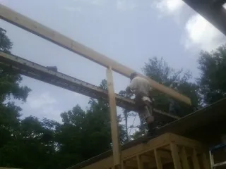Carpenter setting a ridge beam over a new addition frame — Ice Dam Removal by Roofing Brothers in Mineral Springs