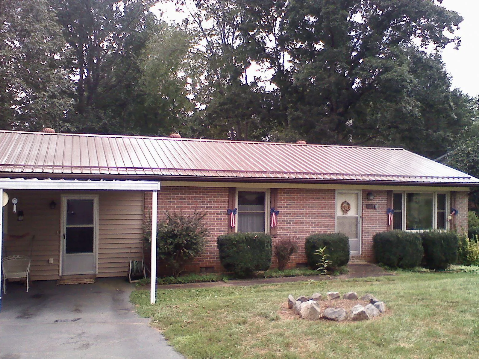 Bronze metal roof and carport on a brick ranch home — Roof Repair work by our crew in Mineral Springs