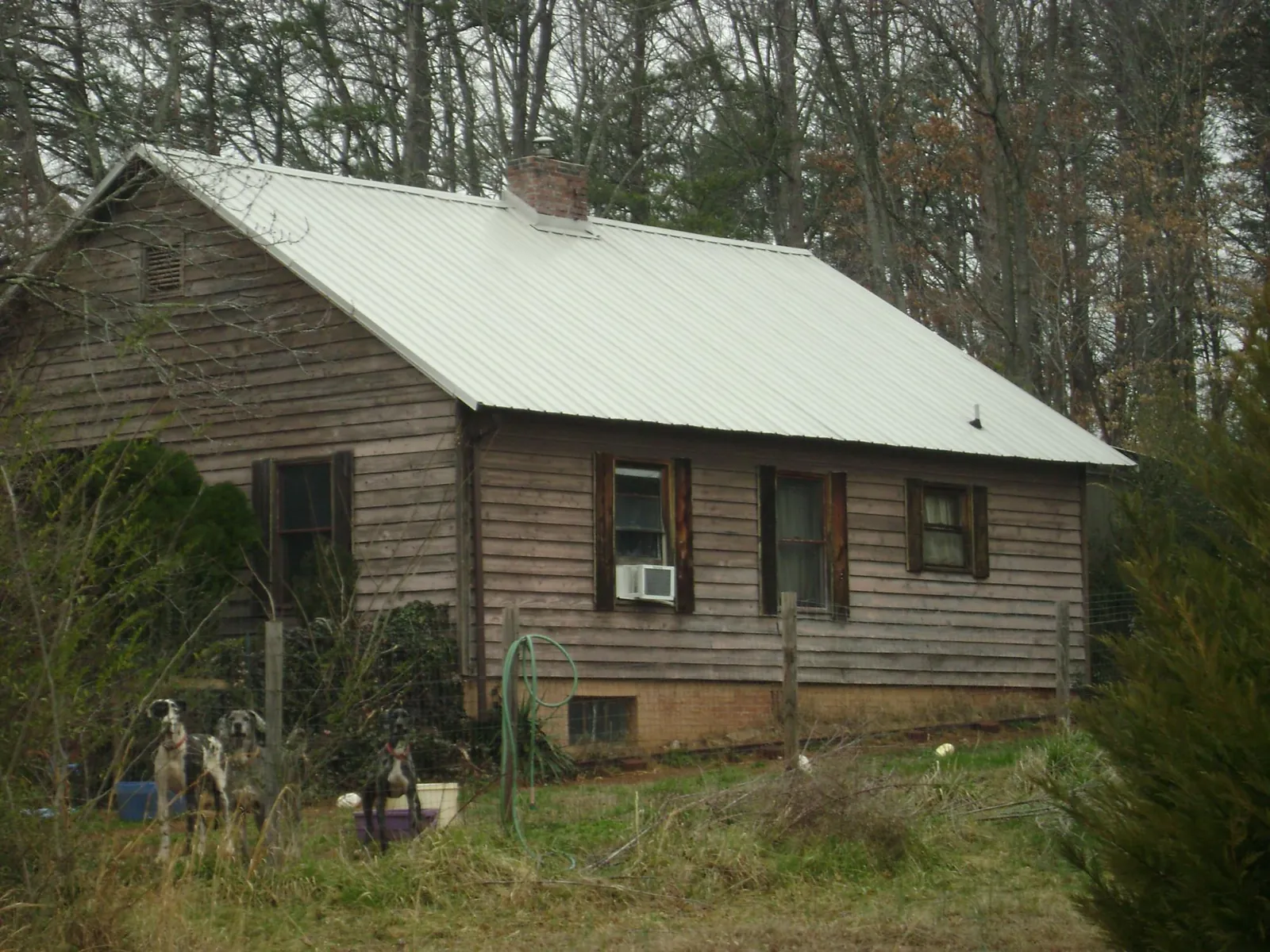 White metal roof on an old wood sided farmhouse, from a Metal Roof Installation job in Mineral Springs